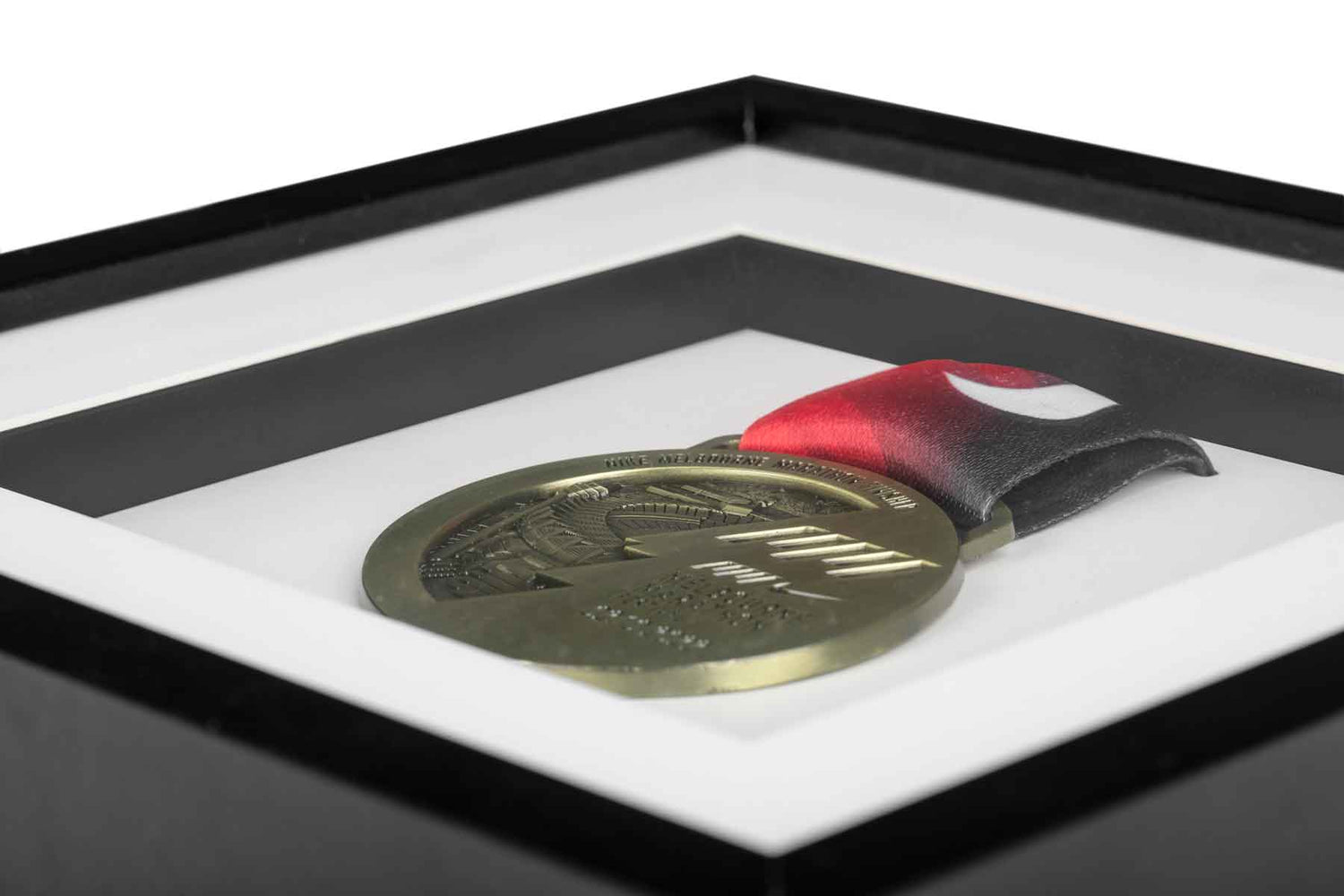 Close up photo of gold medal in black frame