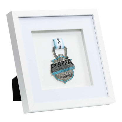 Silver medal from the Portsea Running festival framed in a white square frame, Left angle