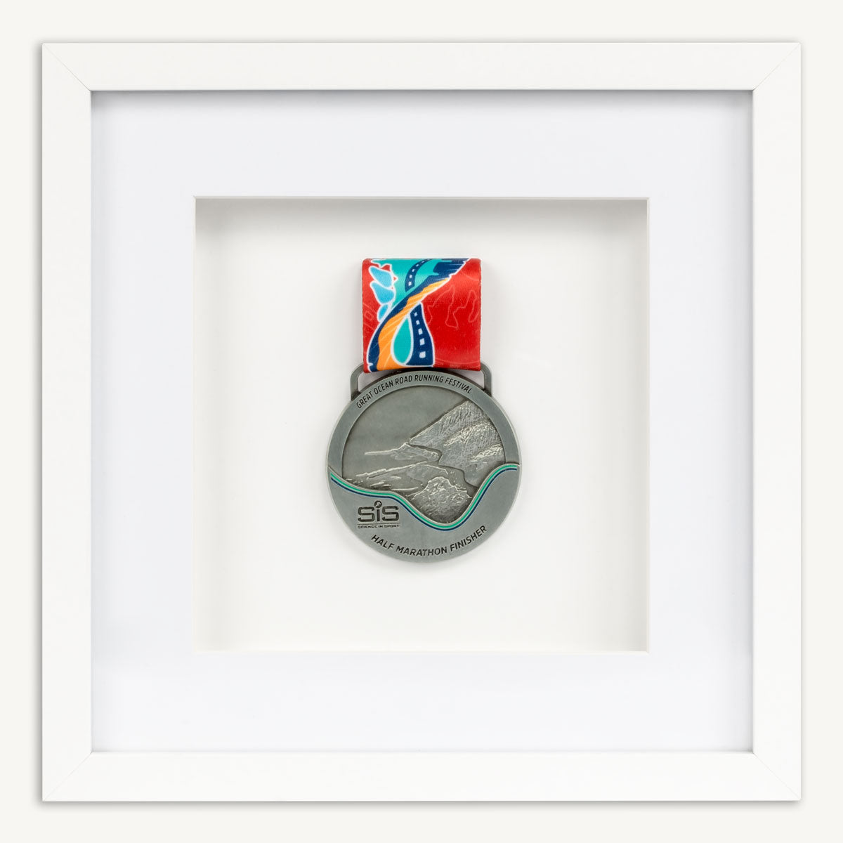 Silver Great Ocean Road Half Marathon running medal in a white square frame. 