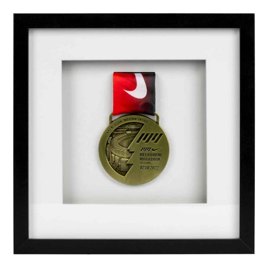 Gold medal from the Melbourne Marathon framed in a Black square frame, front on angle