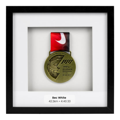 Gold medal from the Melbourne Marathon framed in a Black square frame, front on angle. With personalisation Label 