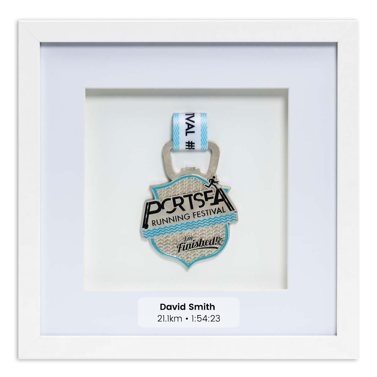 Silver medal from the Portsea Running festival framed in a white square frame, front on angle. With Personalisation Label. 