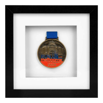 Red, Blue and gold medal from Run Melbourne in 2009 framed in a Black square frame, front on angle