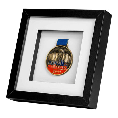 Red, Blue and gold medal from Run Melbourne in 2009 framed in a Black square frame, on angle