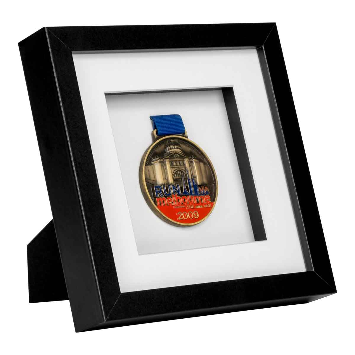 Red, Blue and gold medal from Run Melbourne in 2009 framed in a Black square frame, on angle